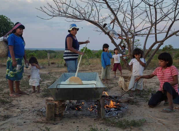 Teda, 62 anos, prepara a farinha de mandioca ao lado de seus netos. (Foto: Lalo de Almeida)