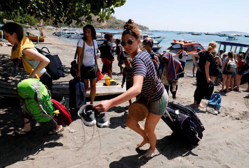 Turistas estrangeiros deixam ilha de Gili nesta segunda-feira (6). Terremoto atingiu a regi&atilde;o no domingo (5)  (Foto: Beawiharta/ Reuters)