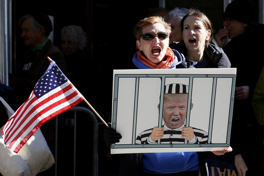 Manifestantes protestam no escritório do promotor distrital de Manhattan na cidade de Nova York contra Trump, que pode ser indiciado por pagar estrela pornô com dinheiro público