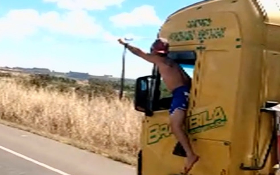 Motorista de caminhão é flagrado dirigindo com corpo para fora da cabine na BR-060 — Foto: Reprodução/TV Anhanguera 