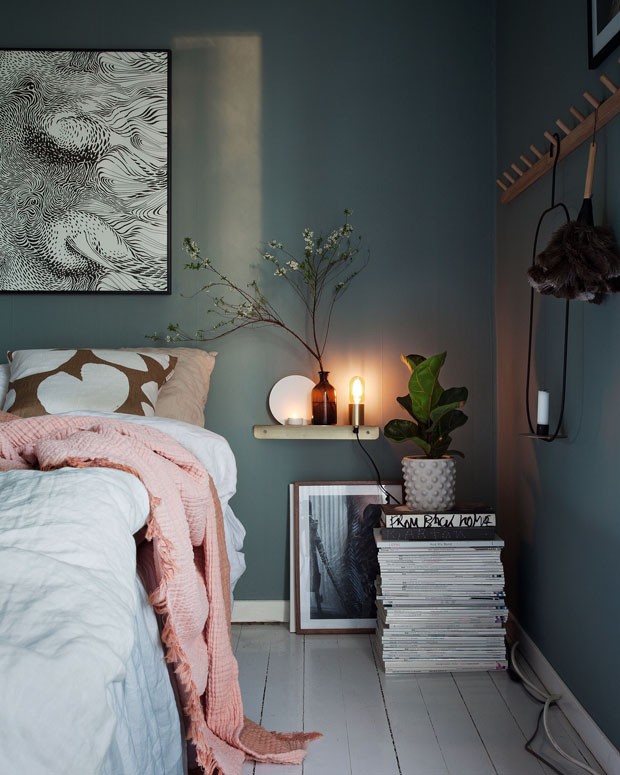 Elementos naturais trazem leveza para quarto com paredes cinza (Foto: Decoração contrasta tons acinzentados com móveis de madeira clara e lustre de fibra natural)