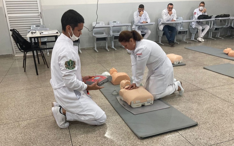 Alunos realizam massagem cardíaca em boneco durante aula no curso de medicina— Foto: Reprodução