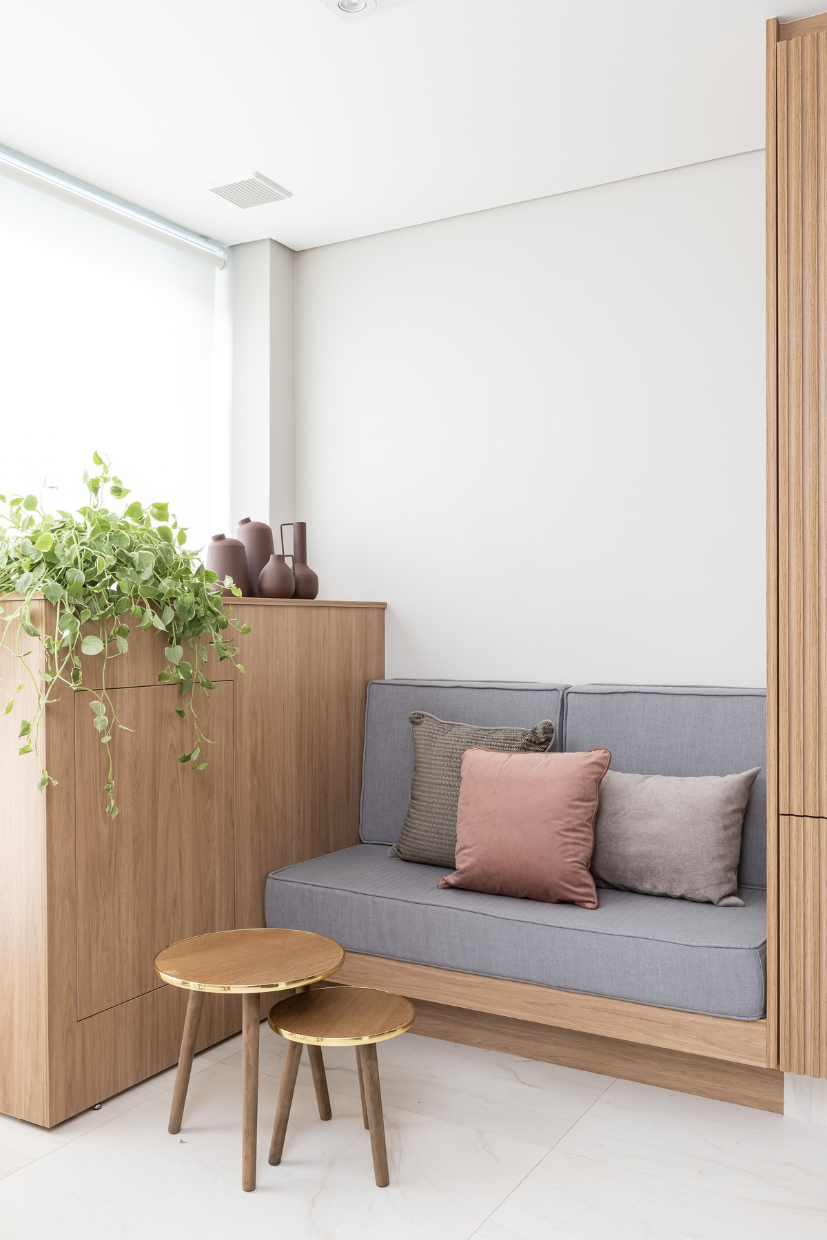 VARANDA | Na varanda, o armário divide o pequeno sofá e permite armazenar vassouras e roupas suja. Objetos de decoração são do  Club Design Decor (Foto: Monica Assan / Diuvlgação)