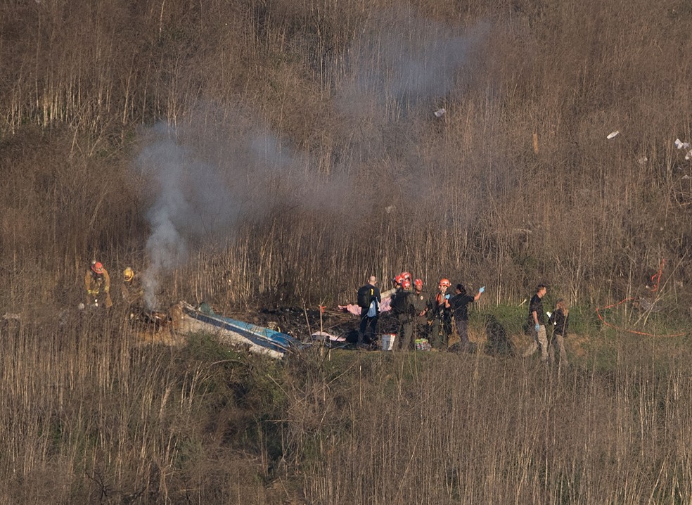 Bombeiros trabalham no local onde o helicóptero que transportava o ex-jogador Kobe Bryant caiu no domingo (26), na Califórnia (EUA)  — Foto: Marca Ralston / AFP