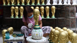Réplicas em gesso do troféu da Copa do Mundo da Fifa são produzidas em uma oficina em Hanói, Vietnã  — Foto: NHAC NGUYEN/AFP