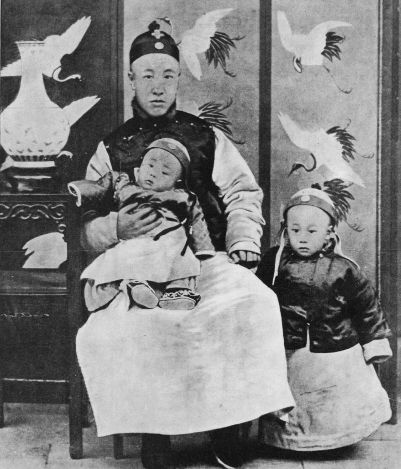 BBC 1909: Príncipe Chun, regente e controlador da nação, com seu filho mais novo ajoelhado e Puyi (1906-1967), Imperador da China, ao seu lado (Foto: Getty Images via BBC)