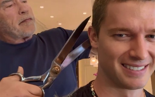 Arnold Schwazenegger usa megatesoura para cortar os cabelos do filho