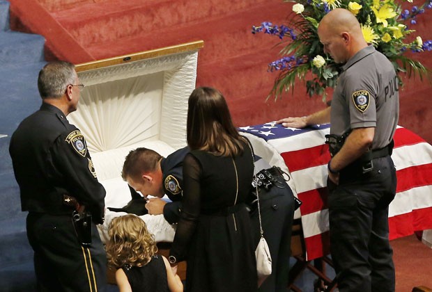 O policial Ryan Stark homenageia o cachorro Kye durante seu funeral nos EUA. Animal era da polícia de Oklahoma (Foto: Sue Ogrocki/AP)