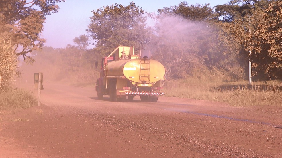 Caminhão-pipa joga água em trecho da MGC-497 para evitar formação de nuvem de poeira — Foto: TV Integração/Reprodução