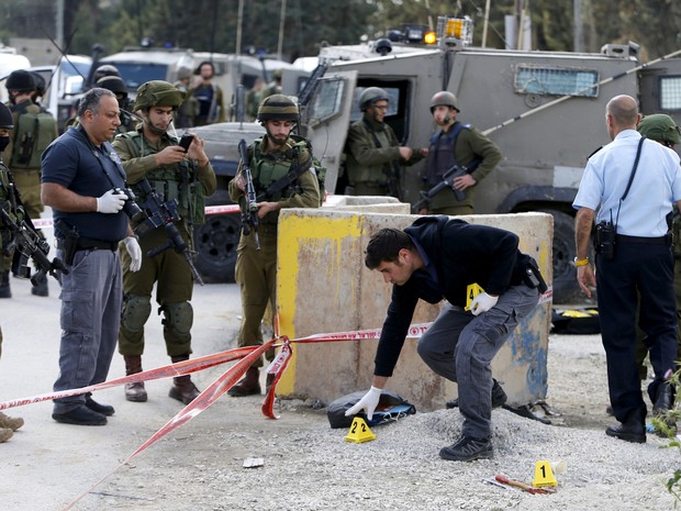 Forças de segurança israelenses inspecionam local onde disseram que palestina foi morta após tentar atacar um soldado israelense (Foto: Mussa Qawasma/ Reuters)