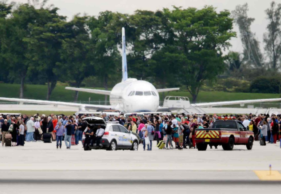 Pessoas na pista do aeroporto de Fort Lauderdale após um atirador ter deixado mortos e feridos (Foto: Lynne Sladky/AP)