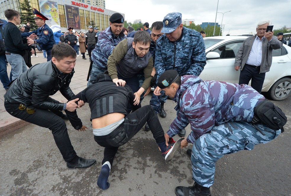 Policiais tentam conter manifestante durante as eleições presidenciais no Cazaquistão neste domingo (9). — Foto: YACHESLAV OSELEDKO / AFP