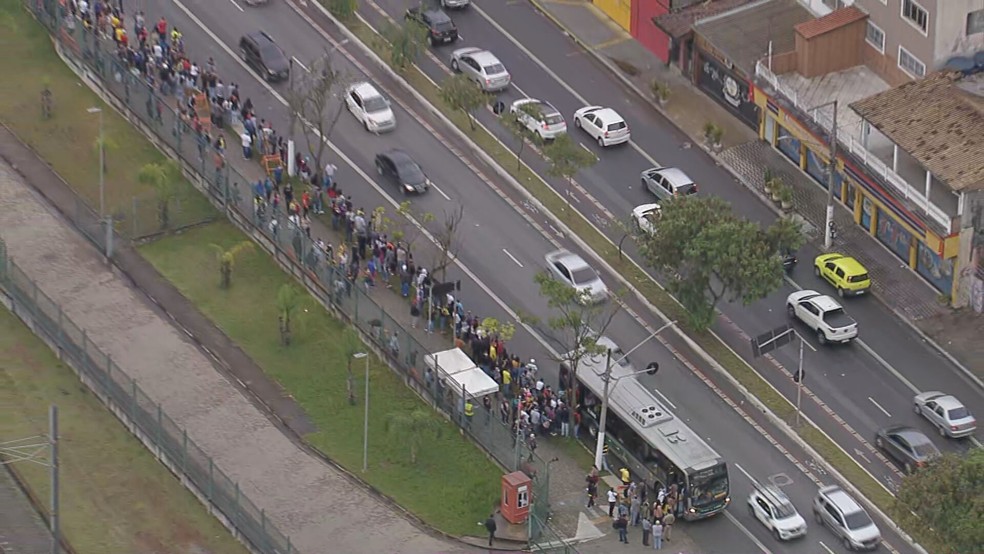 Multidão aguarda em fila chegada de ônibus da operação Paese — Foto: Reprodução/TV Globo