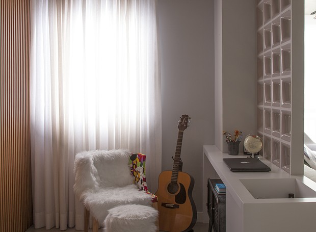 Na sala, o cantinho de leitura e do violão são divididos por cobogós, dando um ar aconchegante na casa (Foto: Luis Gomes/Divulgação)