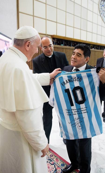 Diego Armando Maradona presenteia o compatriota Papa Francisco durante uma reunião com organizadores, jogadores e convidados da partida inter-religiosa "jogo pela paz", no salão Paulo VI, no Vaticano — Foto: Handout/AFP