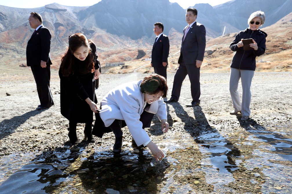 A primeira dama sul-coreana, Kim Jung-sook, enche uma garrafa de plástico com água do lago do Paraíso do Monte Paektu, na Coreia do Norte — Foto: Pyeongyang Press Corps/Pool via Reuters