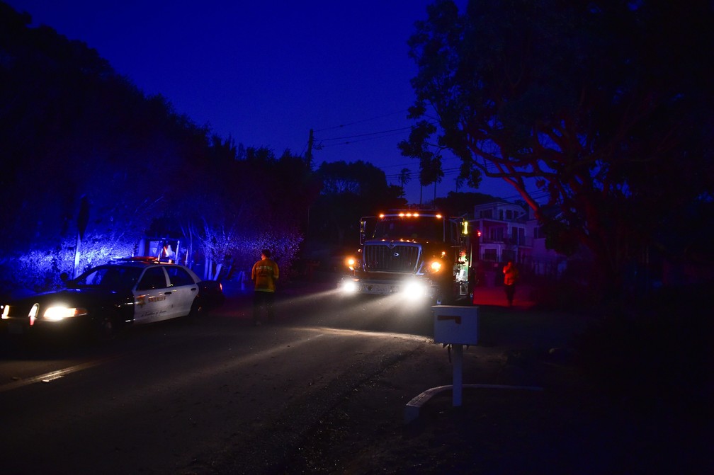 Bombeiros chegam ao entardecer de segunda-feira (12) ao Point Dume em Malibu, na Califórnia — Foto: Robyn Beck / AFP