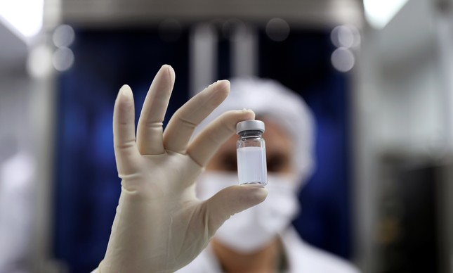 Funcionário segura frasco contendo CoronaVac, vacina da Sinovac Biotech contra a Covid-19 no centro de produção biomédica do Butantan, em São Paulo