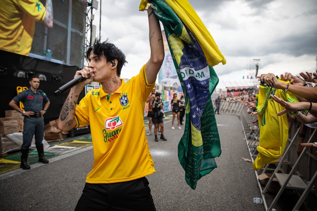 Jxdn recebe bandeira do Brasil de presente de fã durante show no Lollapalooza 2022 — Foto: Fábio Tito/g1