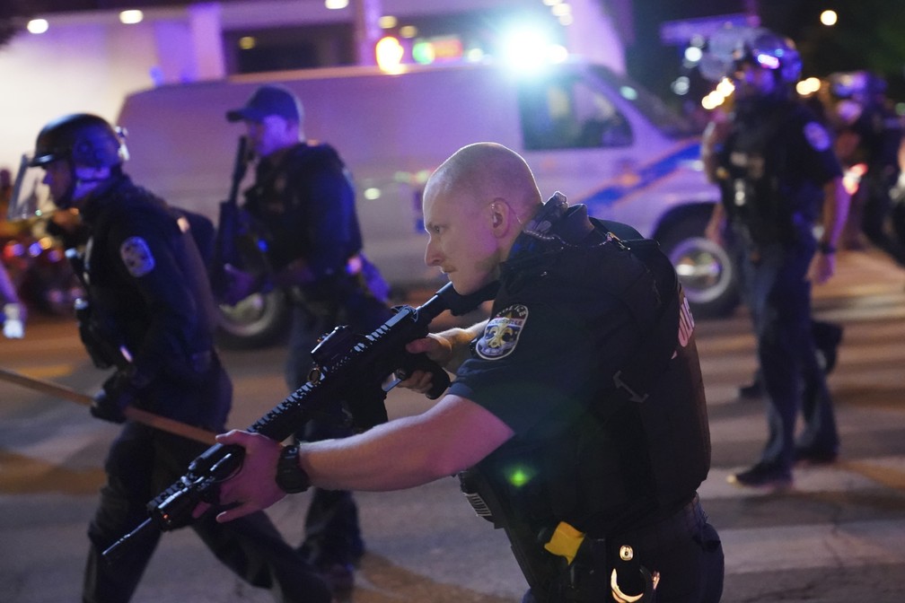 Policiais são vistos em ação após um deles ser baleado durante manifestação em Louisville, Kentucky, na quarta-feira (23) — Foto: AP Foto/John Minchillo