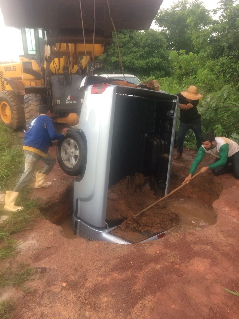 Caminhonete foi ‘engolida’ por cratera de 7 metros em Cáceres; trator foi usado para puxar o veículo (Foto: Arquivo pessoal)