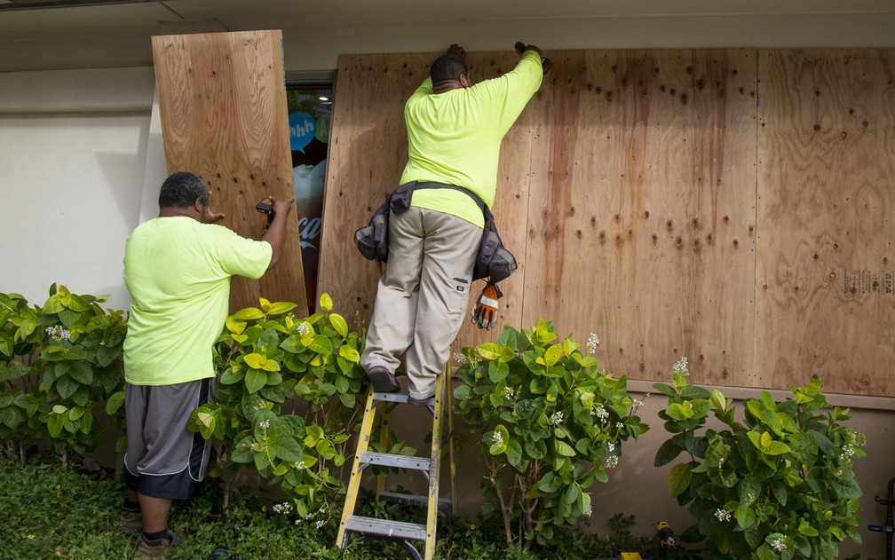 Funcionários colocam placas de madeira em janelas de vidro de uma lanchonete antes da chegada do furacão Lane, na Kalaukaua Ave, em Honolulu, no Havaí, na quarta-feira (22) (Foto: Kat Wade/Getty Images/AFP)