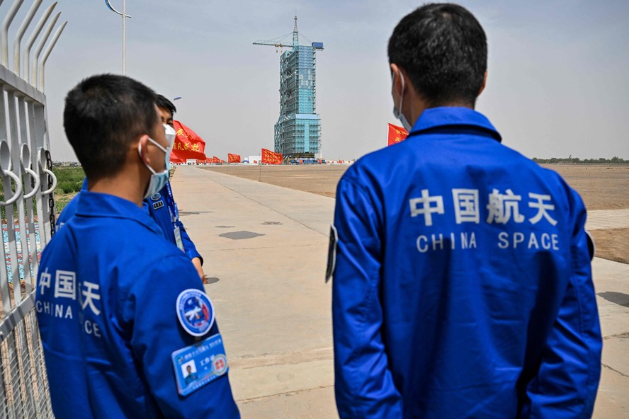 Membros da equipe do programa espacial da China observam plataforma de lançamento da Missão de Voo Espacial Tripulado Shenzhou-16