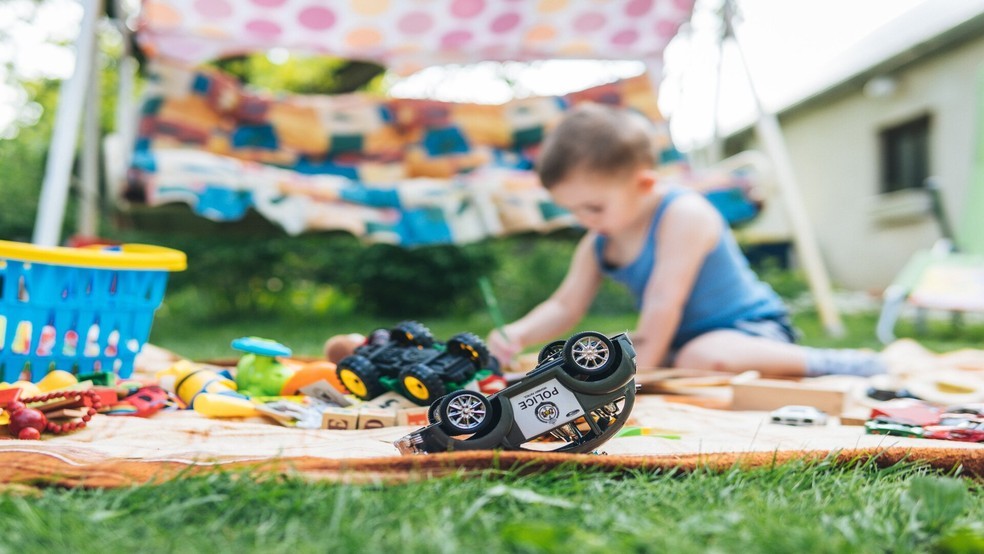 Menino brincando com um carrinho de brinquedo com controle remoto