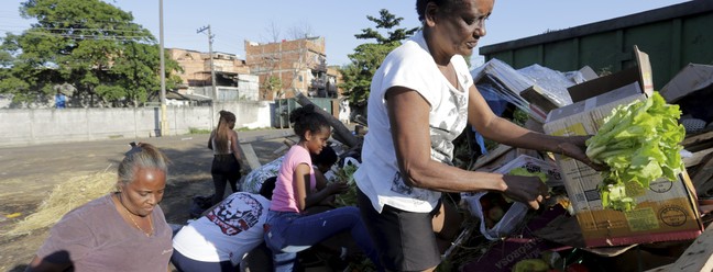 Denise da Silva busca comida nos restos deixados  no lixo da Ceasa — Foto: Domingos Peixoto / Agência O Globo