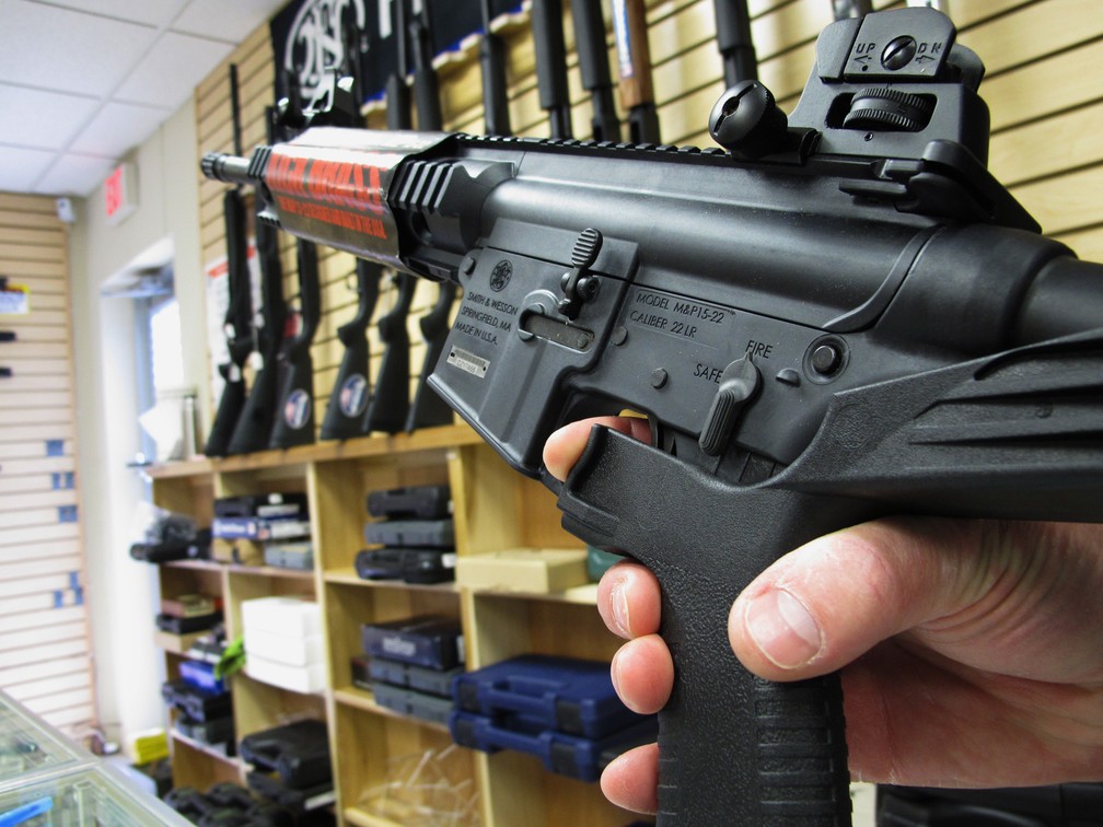 Vendedor mostra um 'bump stock' acoplado a fuzil nos EUA (Foto: AP Photo/Allen Breed)