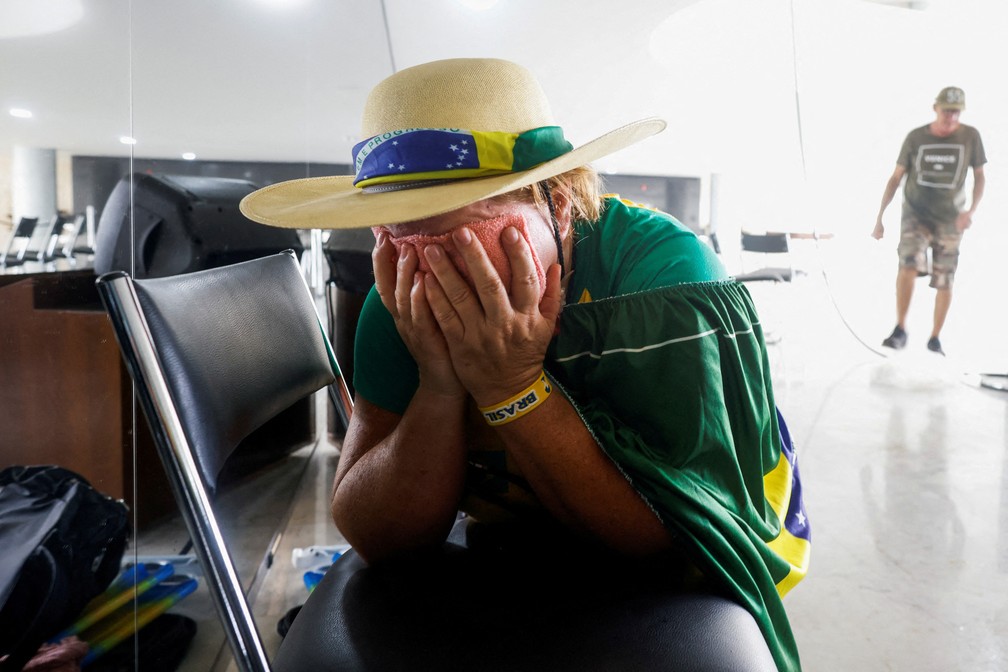 Apoiadora de Bolsonaro cobre o rosto durante invasão em Brasília — Foto: Adriano Machado/Reuters