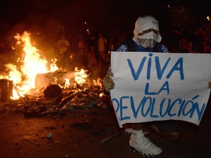 Manifestante com o rosto coberto segura cartaz que diz &#39;Viva a revolução&#39; durante manifestação no Rio de Janeiro (Foto: Luis Gene/AFP)