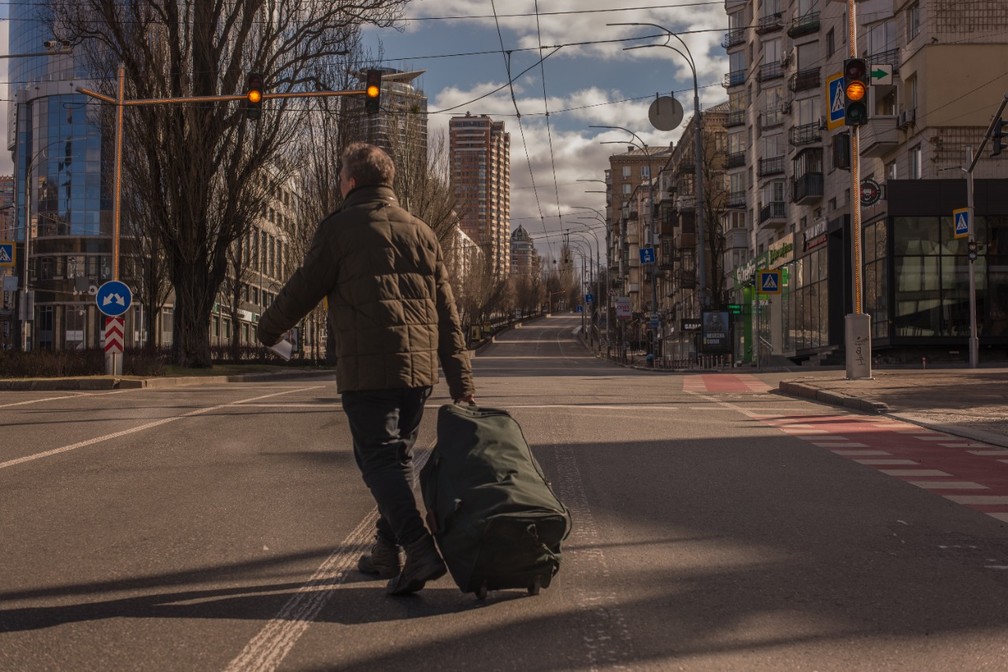 Homem com mala foge por rua de Kiev — Foto: Gabriel Chaim/g1