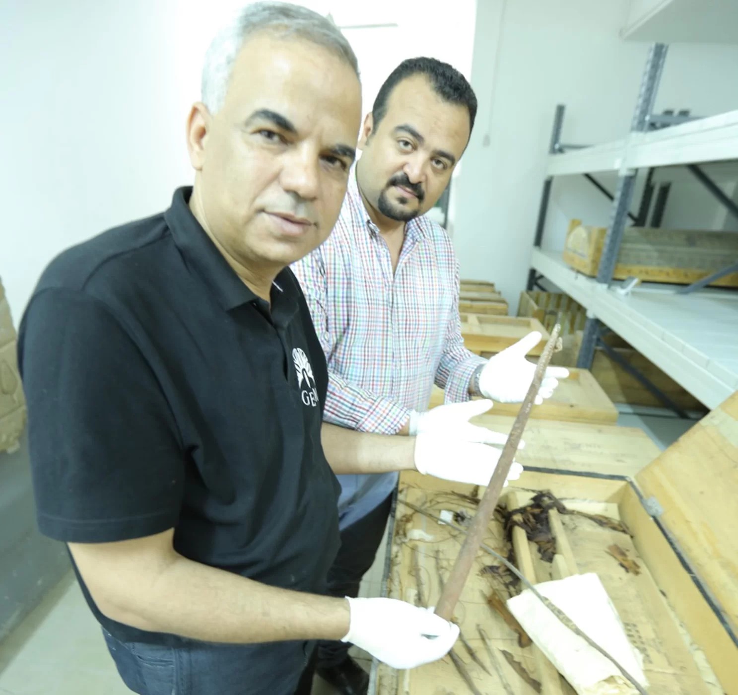 Pesquisadores Eissa Zidane e Mohammed Atwa estudando os barcos de madeira (Foto: Luxor Museum)