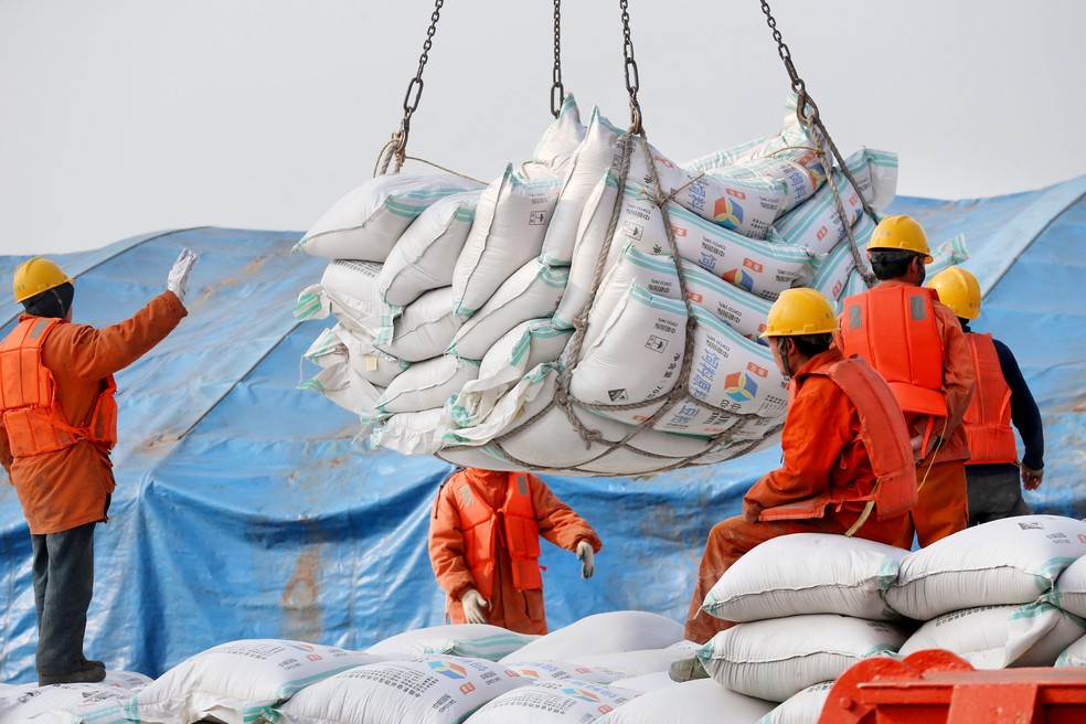 China retalia tarifas dos EUA e adota taxas sobre importações de soja, carros e aviões. Na foto, trabalhadores movimentam carga no porto de Nantong, em imagem de arquivo. (Foto: Reuters)