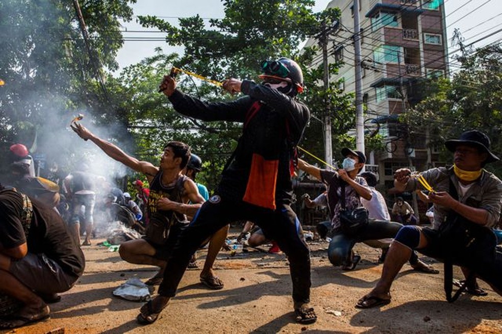 Manifestantes usam estilingues e outras armas caseiras em confronto com forças de segurança em Yangon, Mianmar — Foto: Anônimo, para The New York Times