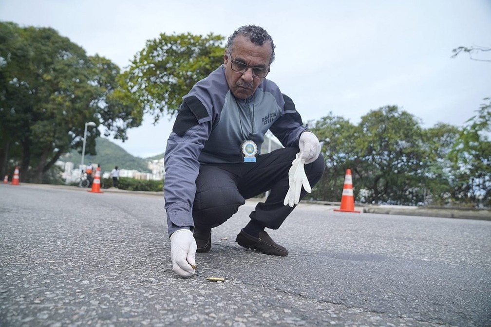 Perito recolhe projéteis na Lagoa Rodrigo de Freitas — Foto: Marcos Serra Lima/G1
