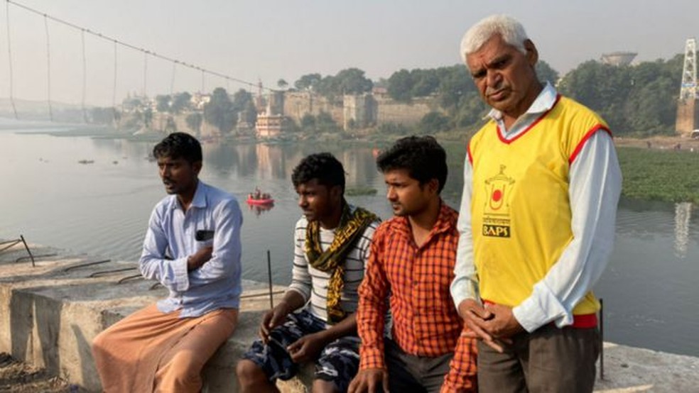 Parbat Govind (em pé) e os demais trabalhadores que participaram do resgate nunca esquecerão o que viram — Foto: BBC/GEETA PANDEY