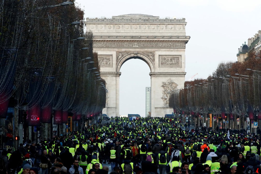 Milhares de manifestantes andam na Champs-Elysées, perto do Arco do Triunfo, em Paris — Foto: Christian Hartmann/Reuters