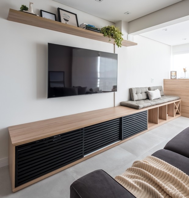 Na hora de escolher o tamanho da TV, é importante observar a proporção em relação aos móveis do ambiente, como o rack e o sofá, além da parede (Foto: Nathalie Artaxo / Divulgação)