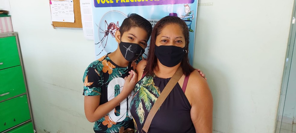 A dona de casa Elizete de Lima Damasceno levou o filho Julio Cesar para se vacinar nesta terça (18) em Rio Branco — Foto: Murilo Lima/Rede Amazônica