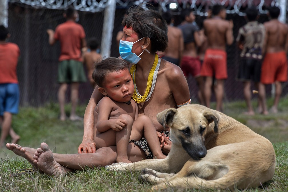 1º de julho - Indígena Yanomami usa máscara ao lado de seu bebê e um cachorro, na terra indígena de Surucucu, em Alto Alegre, Roraima — Foto: Nelson Almeida/AFP