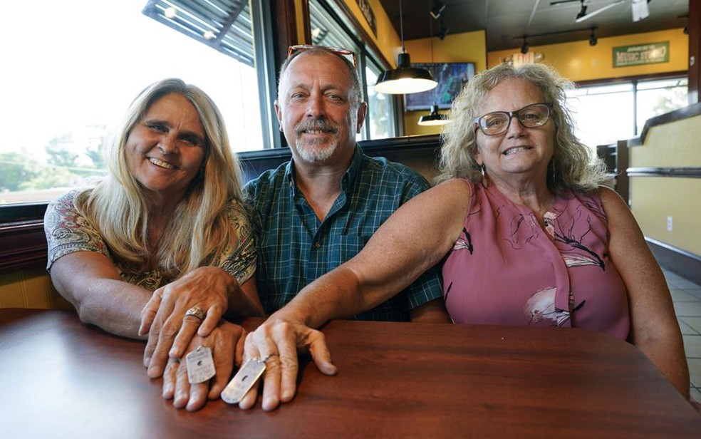 Debby-Neal Strickland e Mylaen Merthe mostram as placas que fizeram após o transplante de rins, durante almoço com Jim Merthe, marido de Debby e ex-marido de Mylaen, em um restaurante em Ocala, na Flórida, em 25 de maio  — Foto:  AP Photo/John Raoux