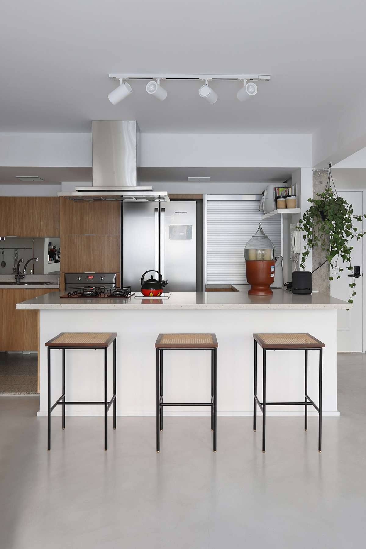 Aberta, a cozinha imprime uma atmosfera mais clean com tons sóbrios, aquecida pela madeira (Foto: Mariana Orsi / Divulgação)