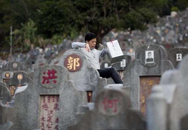 Homem visita jazigo de parente no Cemitério Diamond Hill em Hong Kong: já começa a faltar espaço para enterrar mortos na China (Foto: Jerome Favre/EFE)