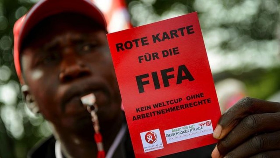 Manifestante dá "cartão vermelho" para a Fifa — Foto: Getty Images via BBC