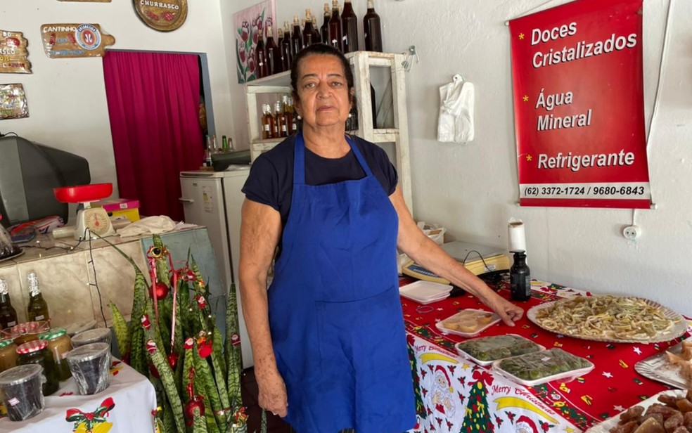 Divina Rodrigues dos Santos ao lado dos doces preparados por ela, na cidade de Goiás  — Foto: Millena Barbosa/g1 