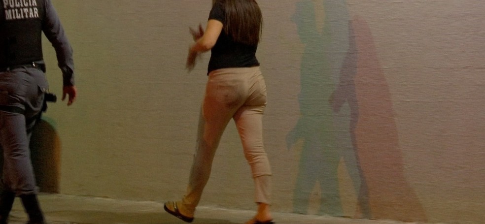 Mulher estava ferida e foi encaminhada para depoimento na Central de Flagrantes de Cuiabá — Foto: TV Centro América/Reprodução