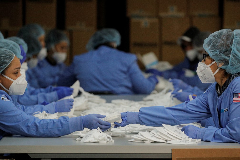 Trabalhadors empacotam máscras N95 em Paterson, Nova Jersey, nos EUA — Foto: BRENDAN MCDERMID / Reuters