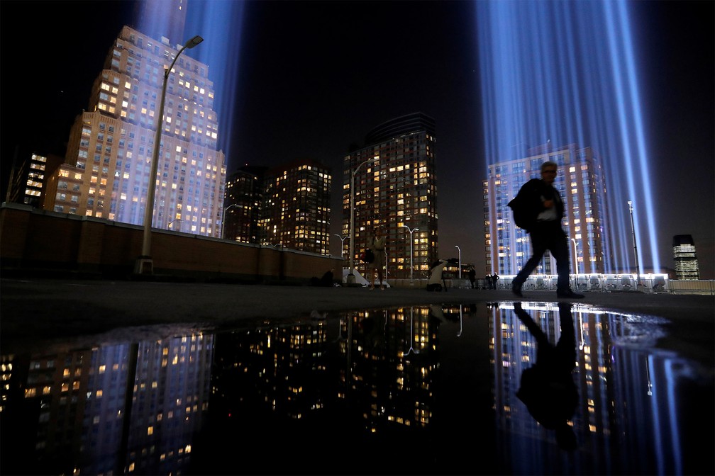 Pedestre passa diante do 'Tribulo em Luz', homenagem em Manhattan às vítimas dos atentados de 11 de Setembro, na noite de terça-feira (10), véspera dos 18 anos dos ataques — Foto: Andrew Kelly/Reuters